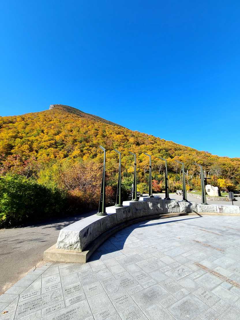 Several tall poles in the Profile Plaza with a mountain in the background.