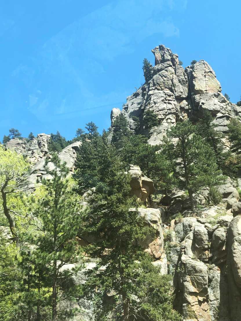 A large pile of rocks with some trees in front of it.