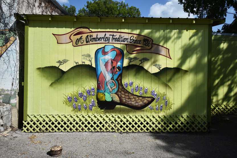 A mural with a painted cowboy boot that reads "A Wimberley Tradition Since 1986"