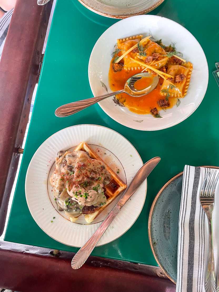 Two small plates at Mint Mark. One is a ravioli and the other is a vegetarian "chicken" and waffle.