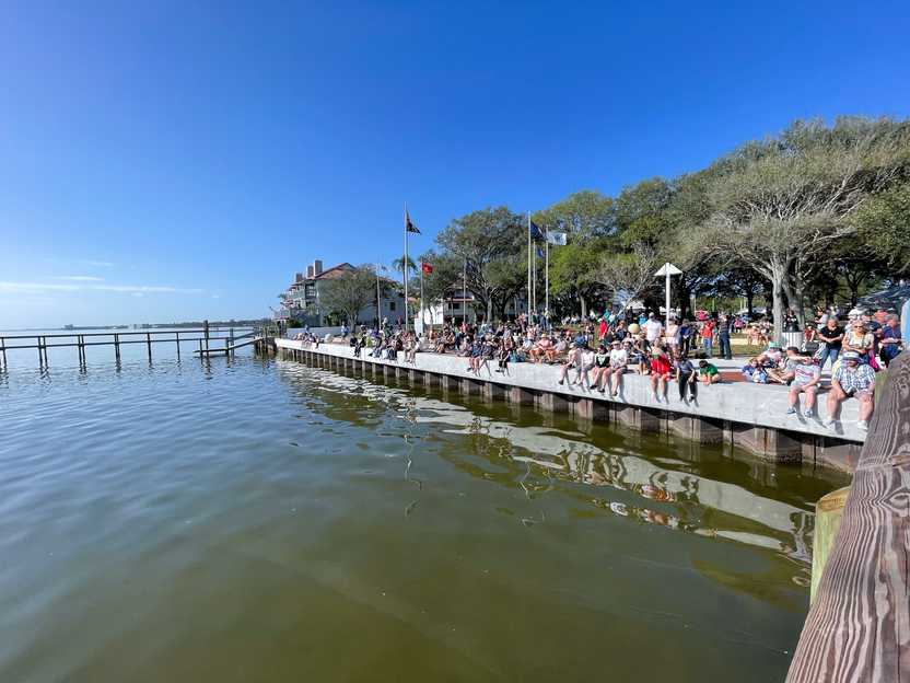 Several people sitting on the shore at Space View Park waiting for the rocket launch.