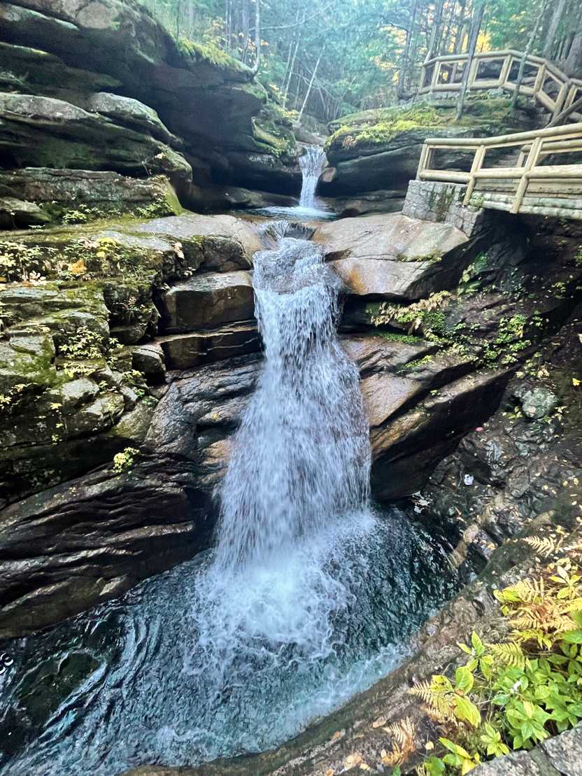 A waterfall flowing down some rocks that resemble a stair-stepping pattern.
