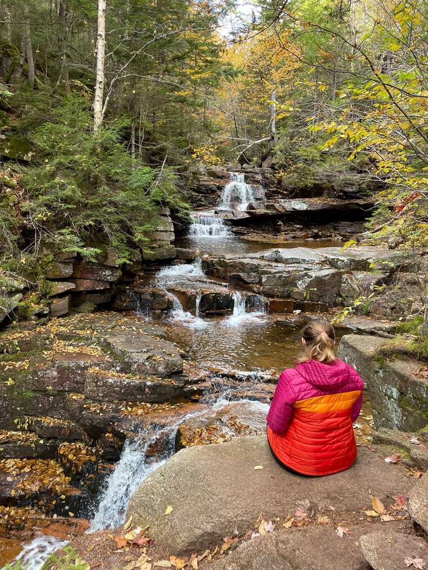 Lydia sitting in front of Bemis Falls along the Bemis Brook Trail