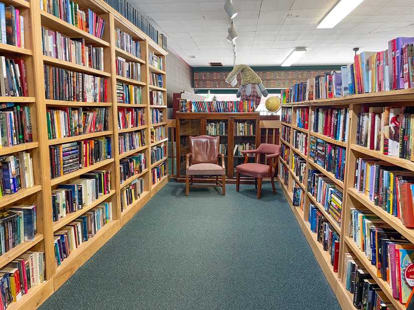 A room with bookshelves and chairs in Books Revisited
