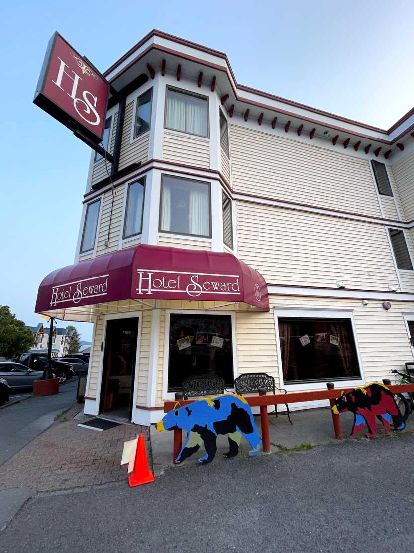 The exterior of Hotel Seward, a cream-colored building with red awnings.