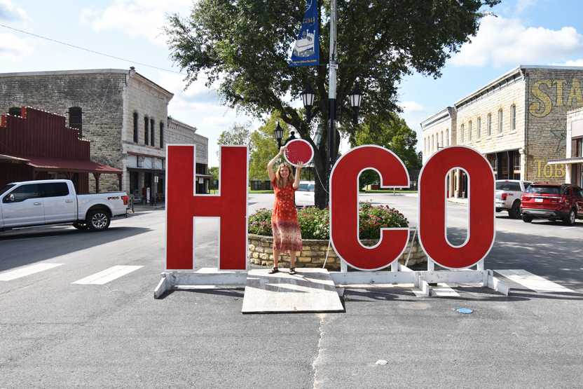 Lydia holding the dot of the i up in the word "Hico"