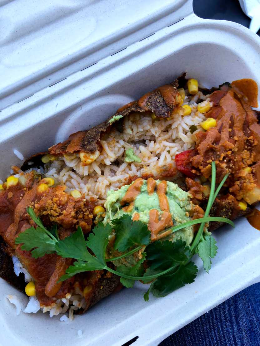 A close up of a dish that includes rice, guacamole, corn and more from ChocolaTree.