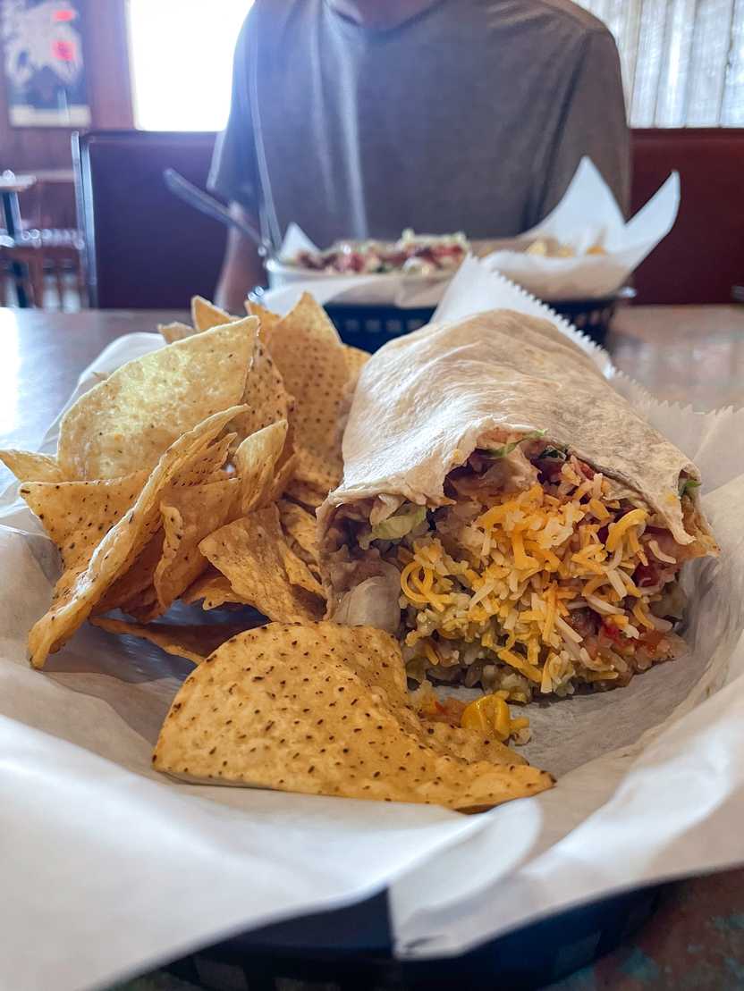 A burrito with chips sitting on a table at Bravo Burrito A burrito with chips sitting on a table at Bravo Burrito