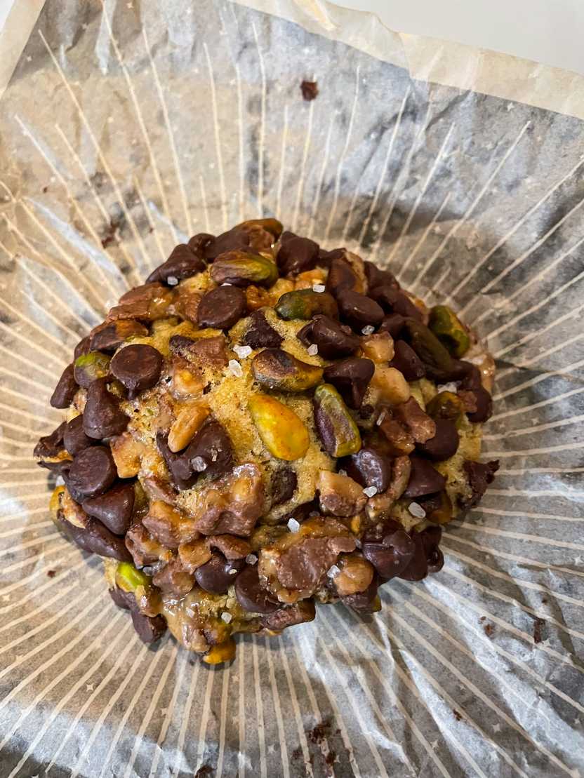 A large cookie with a large amount of chocolate chips. The cookie is from Gideon Bakehouse.
