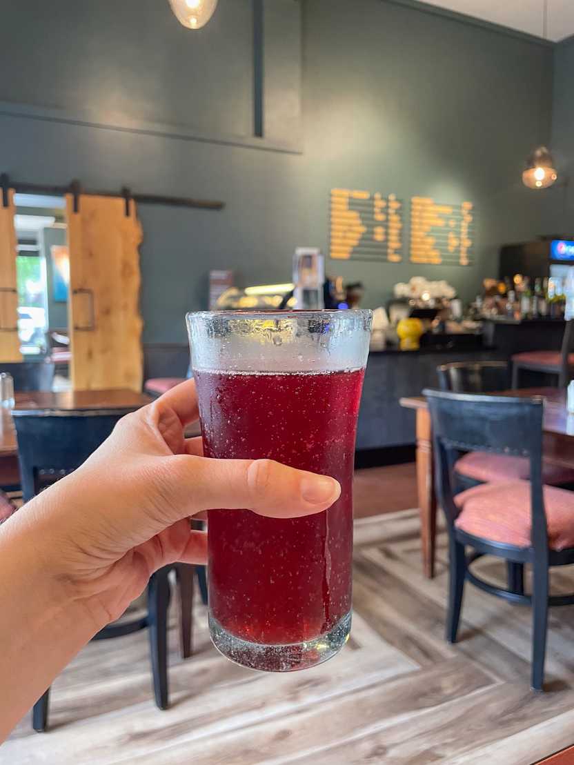 Holding up a red-colored beer at Jules Bistro Holding up a red-colored beer at Jules Bistro