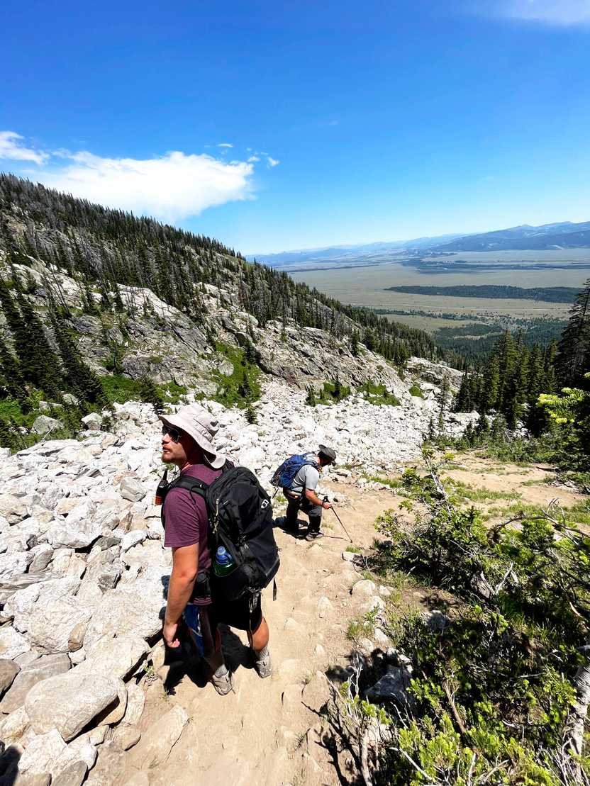 Two people hiking down the steep portion of the hike to Delta Lake.