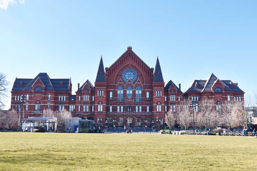The exterior of Music Hall, a large brick building with turrets and a stained glass window.