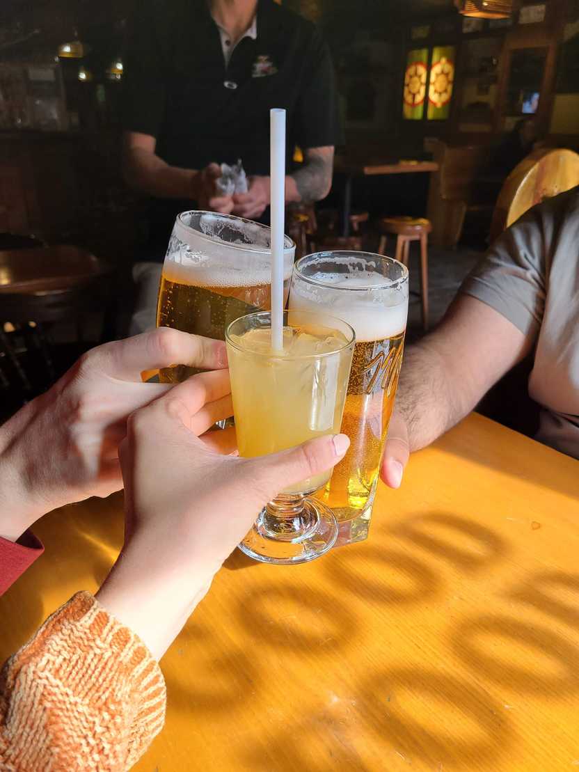 A cheers of 3 drinks at Tommy's Neighborhood Pub.