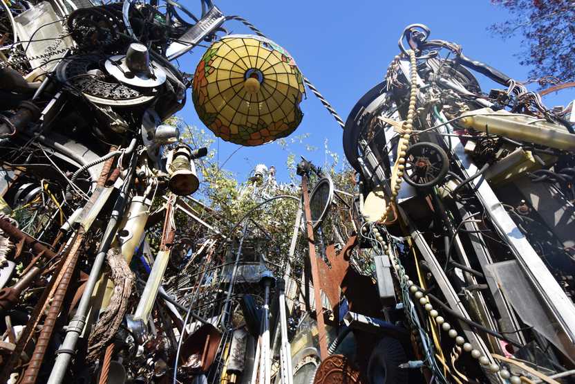 Looking up at the Cathedral of Junk, there is a stained glass lampshade, wheels and all sorts of other metals and materials to make up a structure.