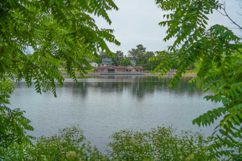 Looking through some trees across Lake George at a building