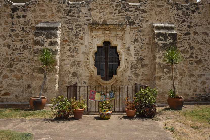 A window at Mission San Jose with some plants sitting outside.