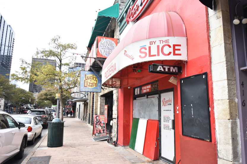 A pizza place next to bars on Sixth Street in downtown Austin.