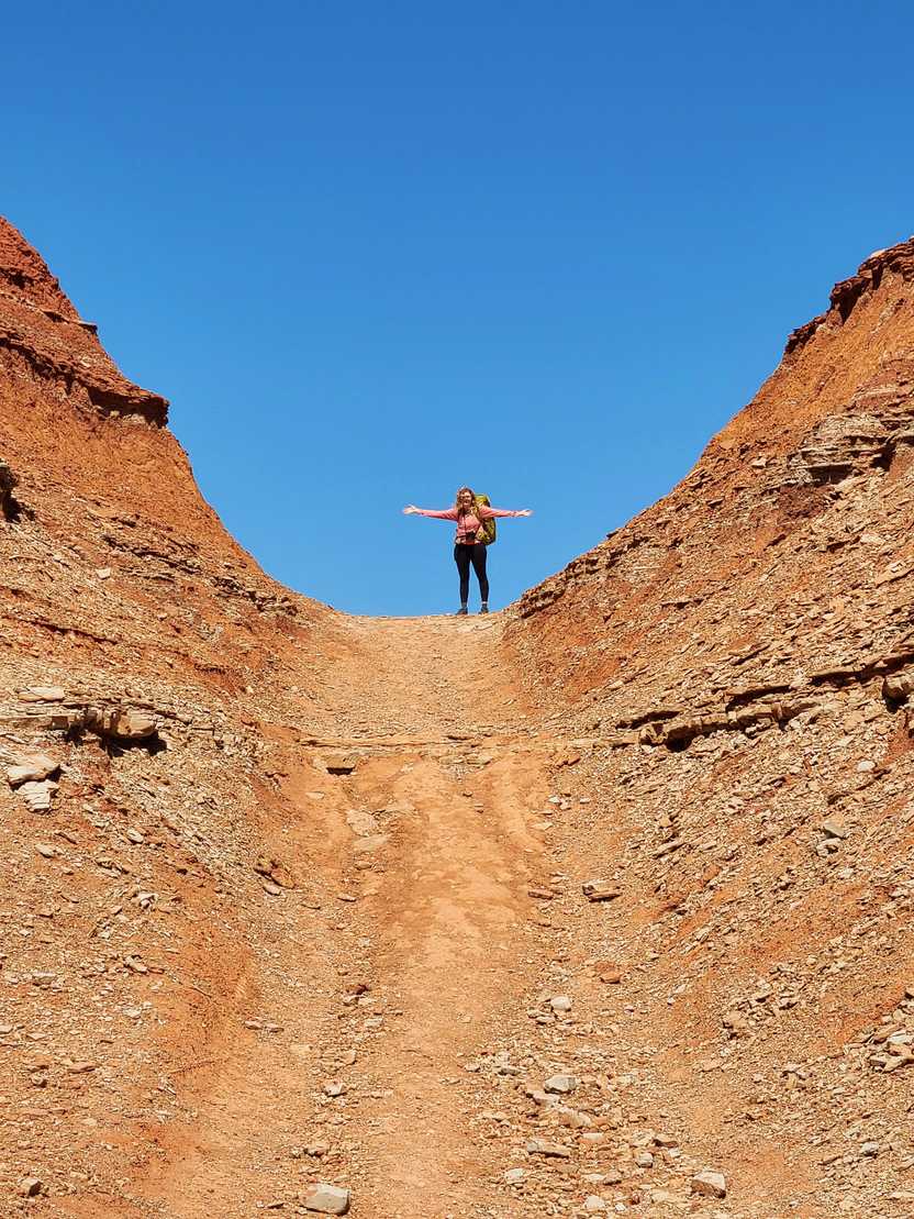 Lydia up a ledge wearing her large backpacking backpack.