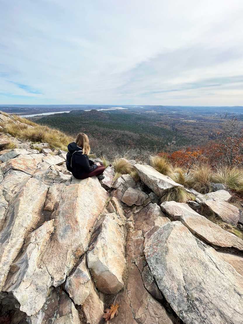 Lydia sitting on a rock looking out at the view from Pinnacle Mountain.