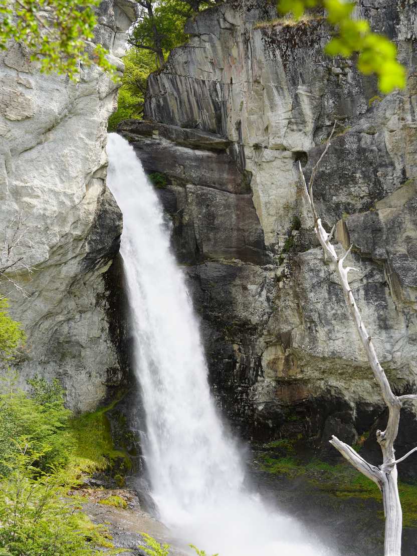 A waterfall flowing out between two tall rock faces.