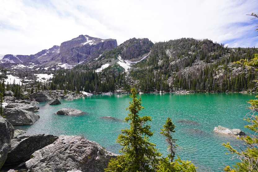 A view looking down at Lake Haiyaha, which is a bright, green color.