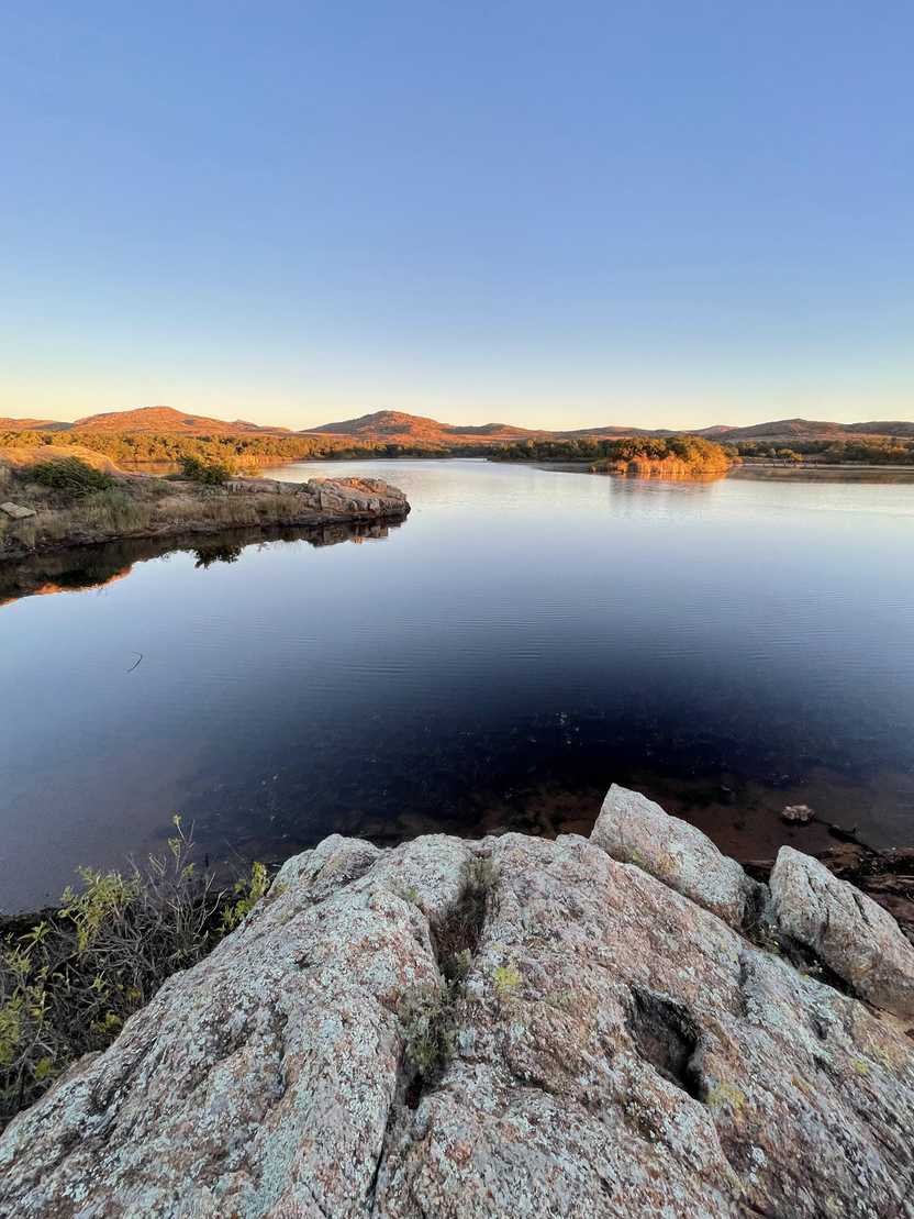 Looking out at the Quan Parker Lake with orange light on the trees across the lake.