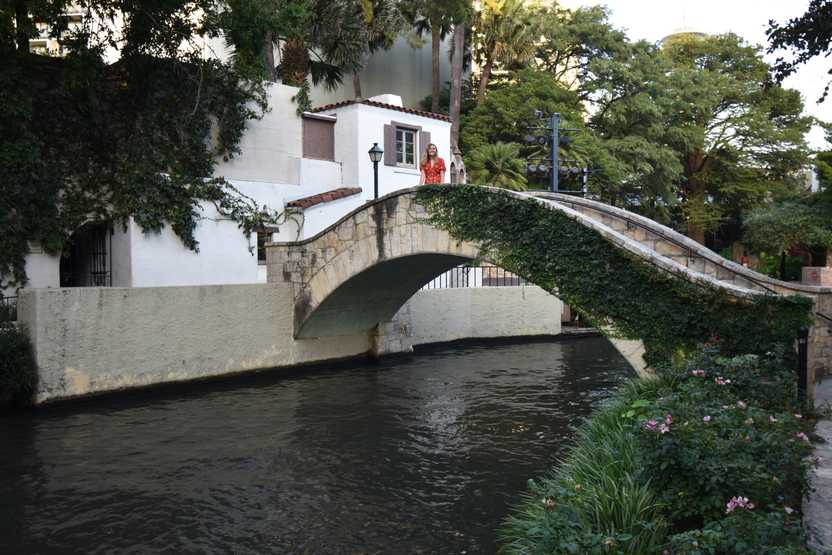 Lydia standing on Rosita's Bridge in downtown San Antonio. Part of the bridge is covered in green vines.