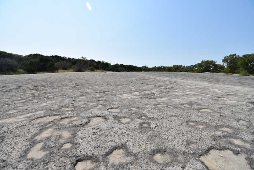 A giant gray slap of rock with some areas that look like craters