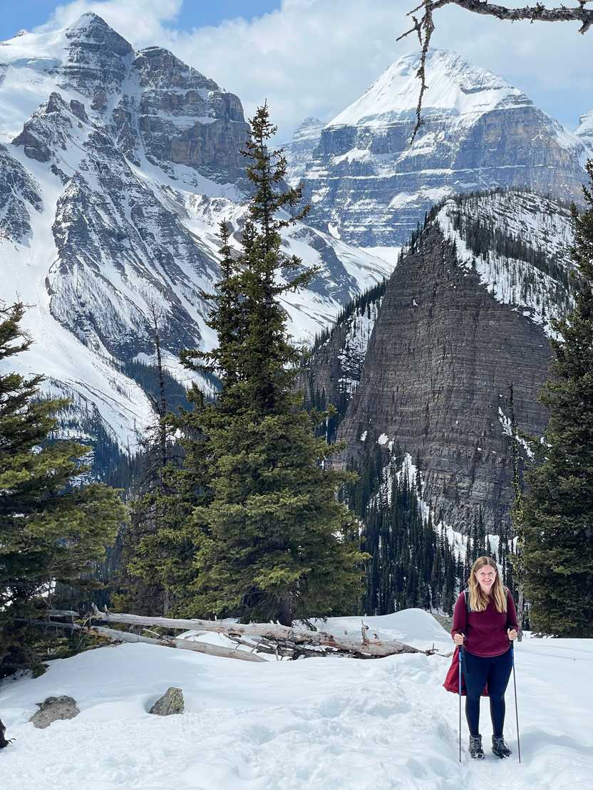 Lydia on a snow-covered hiking trail with a mountain background.