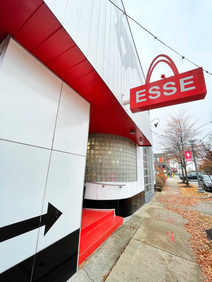 The outside of the Esse Purse Museum. The building is red and white and black arrow points to the door. The outside of the Esse Purse Museum. The building is red and white and black arrow points to the door.