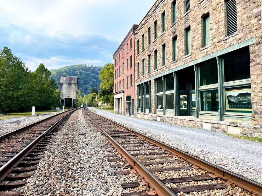 Standing between the train tracks with abandoned buildings on the right at the Thurmond Ghost Town.