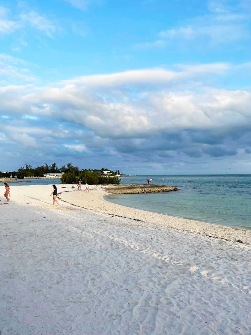 Looking at the sand and ocean of Sombrero Beach as a few people walk by