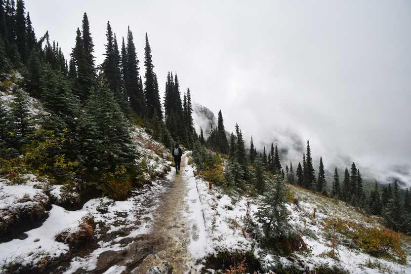 Some hiking on a narrow trail with a little bit of snow on the Highline Trail.