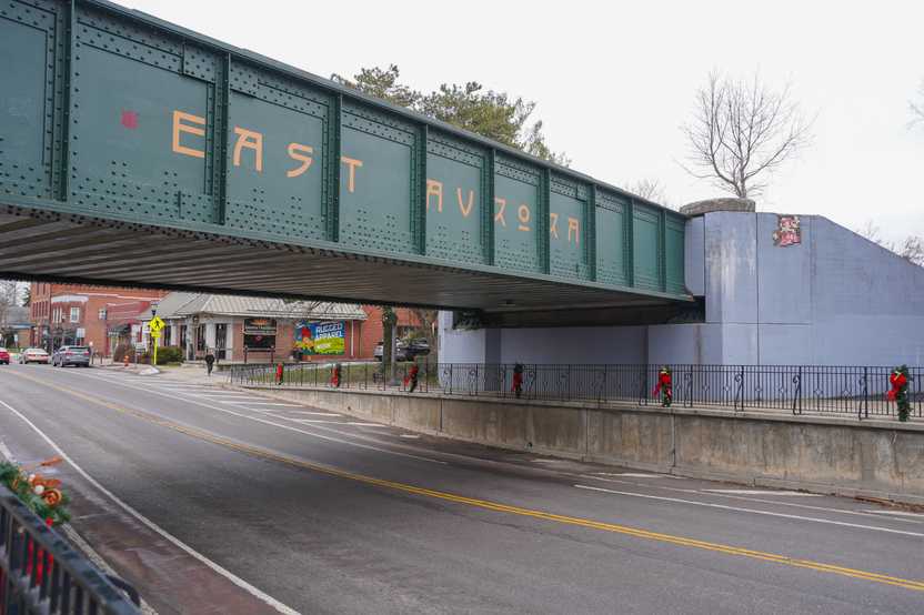 A green bridge that reads 'East Aurora' in yellow letters. The bridge goes over a large road.