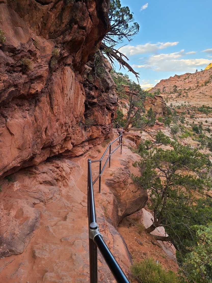 A narrow ledge with a railing on the Canyon Overlook Trail in Zion National Park. A narrow ledge with a railing on the Canyon Overlook Trail in Zion National Park.