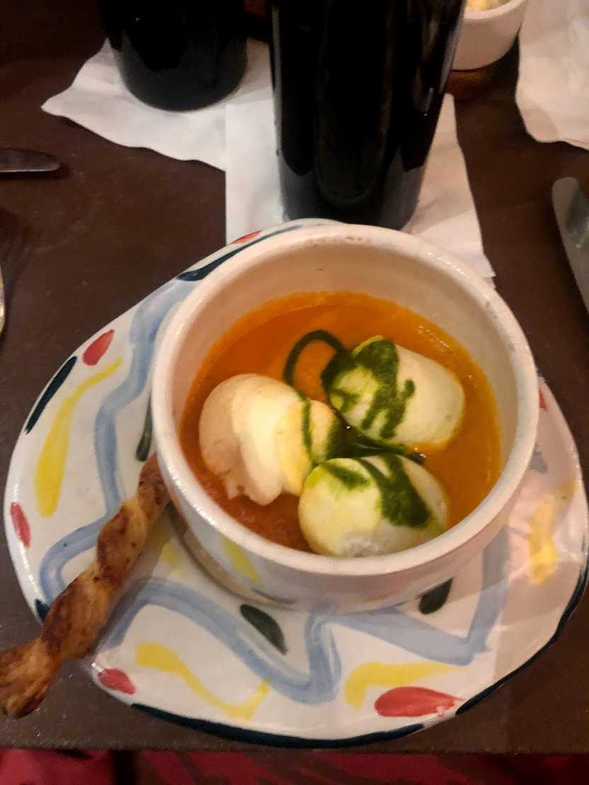 Tomato soup with giant cheese balls served on colorfully painted ceramics.