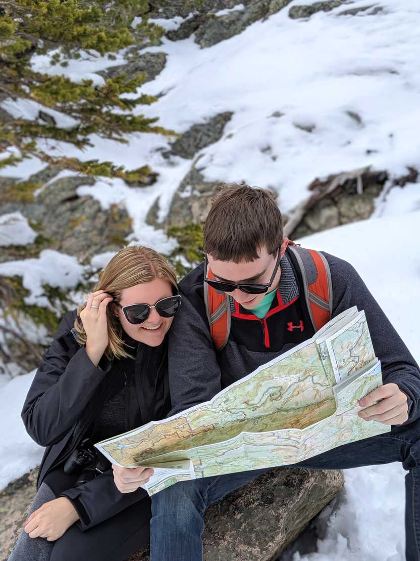 Lydia and Joe reading a paper map with snow behind them.