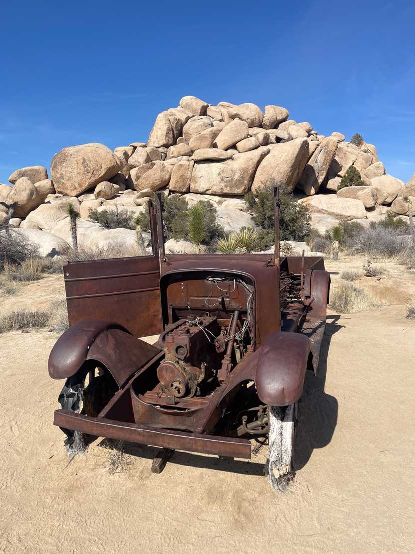 A very old pick up that has been covered in rust.