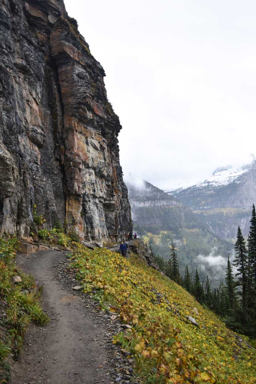 A trail along a tall rock face on the Highline trail.