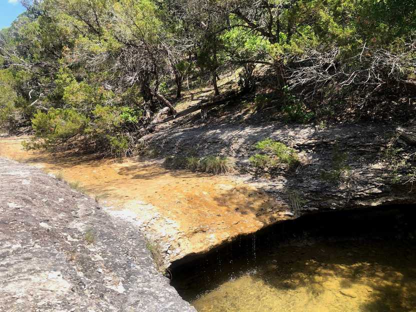 A small, trickling waterfall on the Buckeye Trail in Dinosaur Valley State Park.