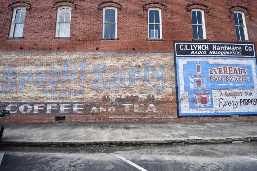 Faded murals on a brick building in downtown Hico. One reads "Bright and Early Coffee and Tea"