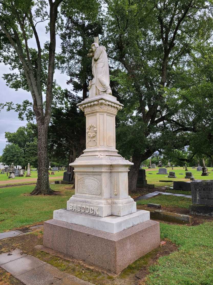 A large gravestone with a Jesus figure on top.