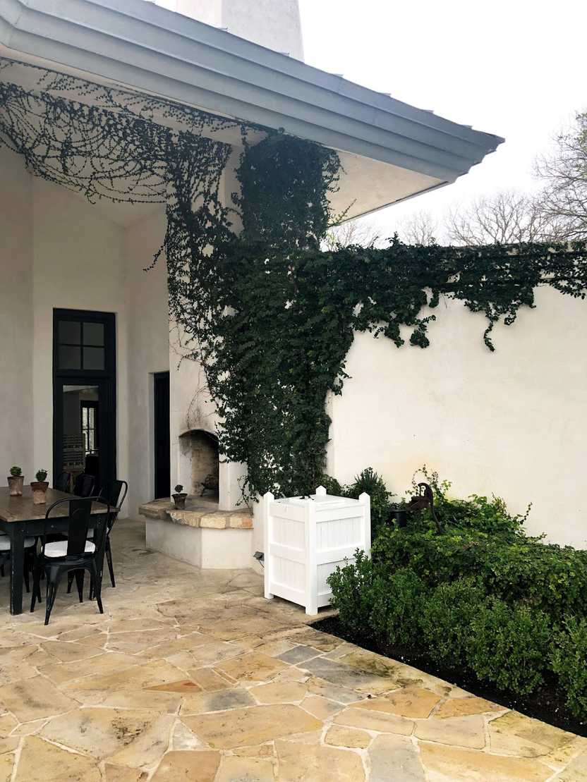 The exterior of Signor Vineyards. Green vines hang on white walls.