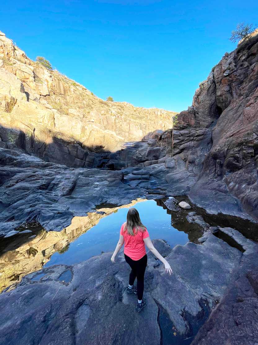 Lydia standing and looking out at the water on the Forty Foot Hole trail in the Wichita Mountains.