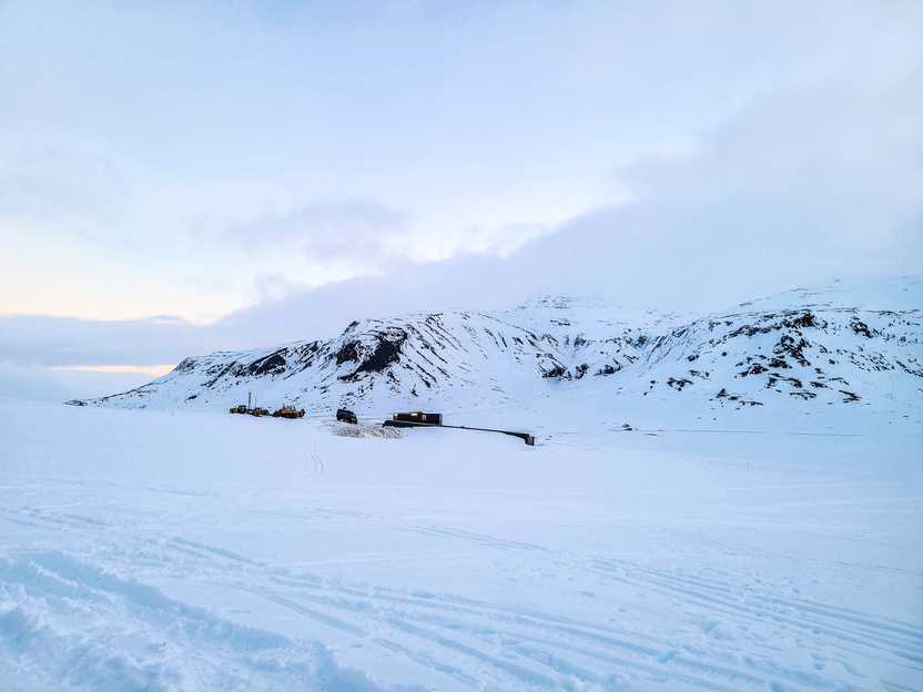 A snow covered glacier with a mountain in the background.