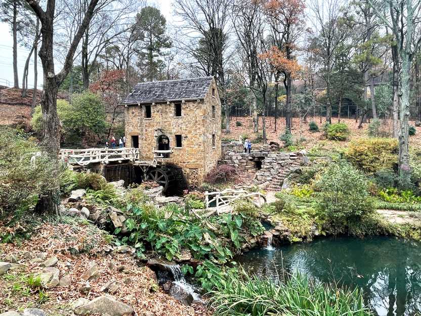A historic looking mill surrounded by greenery.