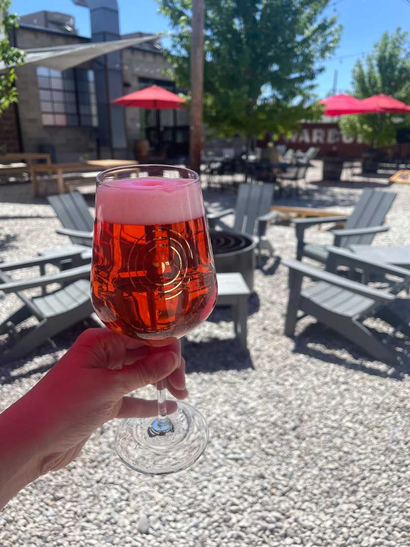 Holding up a beer in the outside patio at Templin Brewing.