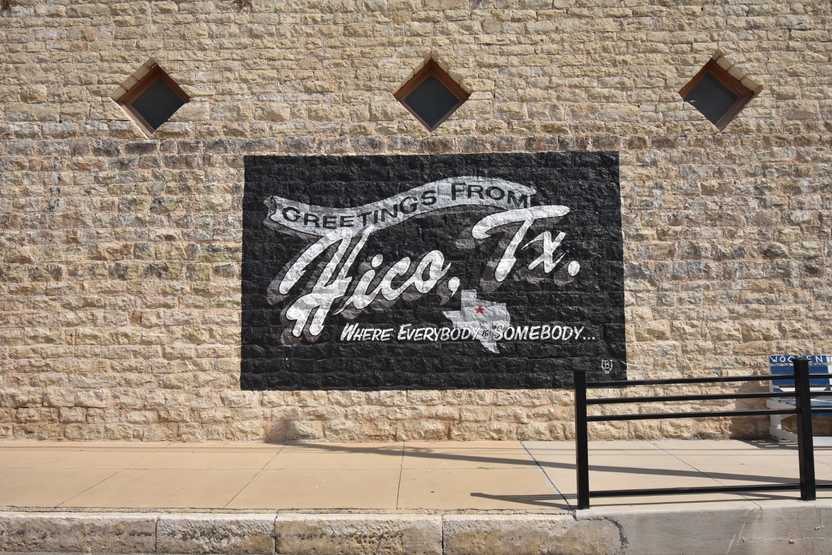A mural that reads "Greetings from Hico, TX, Where Everybody in Someday" A mural that reads "Greetings from Hico, TX, Where Everybody in Someday"
