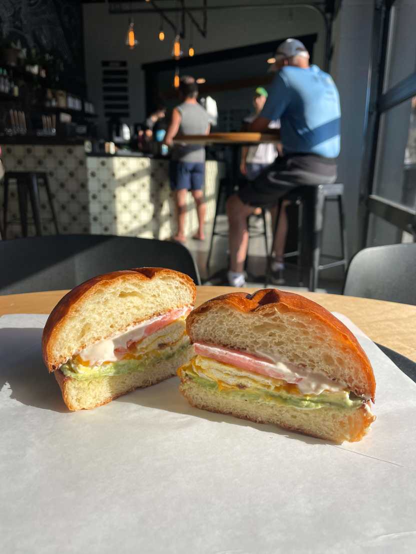 A breakfast sandwich with brioche bread, avocado, eggs and tomato from Push & Pour.
