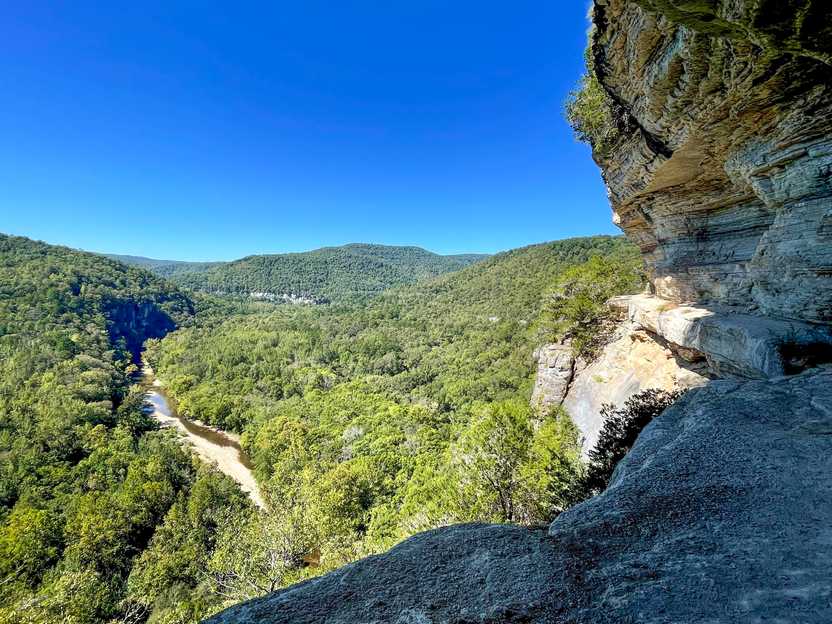 A view of the Buffalo National Park from the Goats Bluff Trail in Arkansas. There is a large cliff face and the river is in the valley down below.